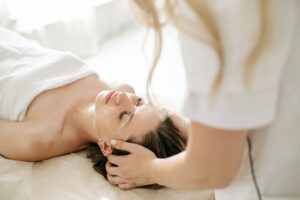 Woman lying on her back on a massage table receiving cranio-sacral massage.